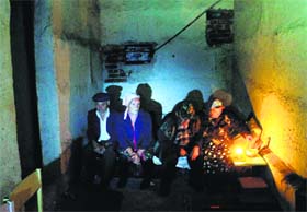 Local residents sit in a basement used as a shelter from artillery fire on the outskirts of Donetsk, on Monday