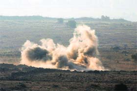 Fighting erupts: A blast is seen near the border fence with the Israeli-occupied Golan Heights on Monday