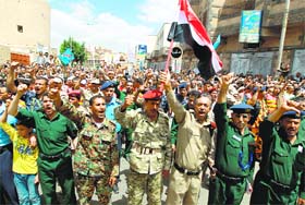 Army and police officers loyal to the Huthi Shiite group take part in a demonstration near the cabinets headquarters in Sanaa calling for the government to resign, on Monday