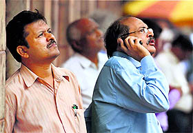 Investors react while watching stock prices at a screen outside the BSE as the Sensex crosses 27,000-mark in Mumbai on Tuesday. 