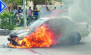 A car catches fire near Karkardooma Court in East Delhi on Tuesday.
