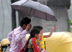 A man holds an umbrella to protect his family from rain in New Delhi on Tuesday. 