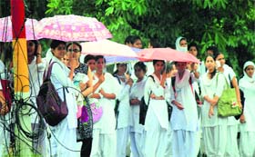 Wet weather: Students protect themselves from rain with umbrellas in Jammu on Tuesday