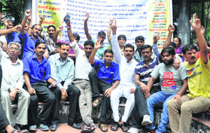 Sanitary employees stage a dharna at Doon Hospital in Dehradun on Tuesday. However, they later called off their agitation and joined duties. 
