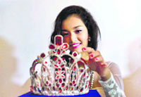 May Myat Noe, Myanmars first international beauty queen and winner of 2014 Miss Asia Pacific World, adjusts $ 100,000 worth crown that she allegedly ran away with, in Yangon on Tuesday. The dethroned beauty queen says she wont return her crown until the pageants organizers apologize for calling her a liar and a thief.