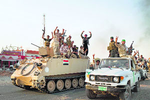Iraqi soldiers wave to a humanitarian aid convoy on way to Amerli after forces broke through to the jihadist-