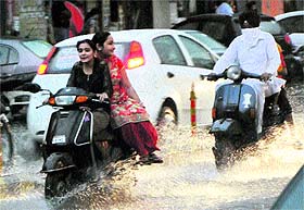 Girls riding a scooter get caught in sudden showers in Amritsar on Wednesday.