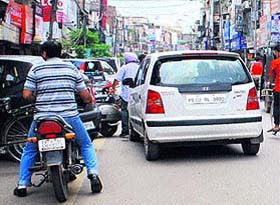 A resident parks his motorcycle behind other vehicles at a wrong spot in Hall Bazar