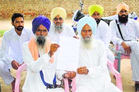 Residents of Kot Shamir village show the document of consent of 11 panchayats for handing over Gurdwara Jandalisar to Baba Baljit Singh Daduwal