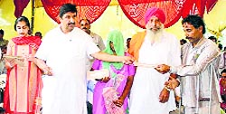 Industries Minister Mukesh Agnihotri distributes cheques to beneficiaries at Haroli in Una on Thursday