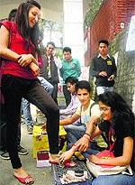 Activists of the ABVP polish shoes during a protest against fee hike at HPU in Shimla on Thursday