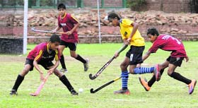Players vie for the ball during a match of the 13th ONGC SN Vohra Memorial Hockey Tournament at the hockey stadium in Sector 18, Chandigarh, on Friday.