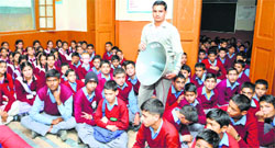 Students of a Senior Secondary Government School listen to Prime Minister Narendra Modis speech through a loudspeaker linked with a radio in Shimla on Friday. Photo: Amit Kanwar