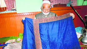 A dealer displays an original pashmina shawl in Srinagar.