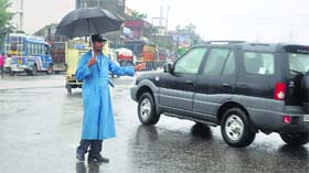 A traffic policeman on duty during heavy rain in Jammu on Friday.