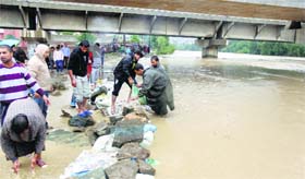 Residents of Kashmir on Friday erect bunds to prevent water from entering residential areas of Bemina area that is submerged due to floods.