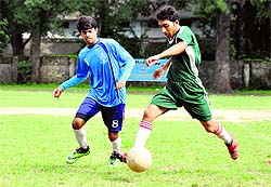 Players vie for the ball during a match in the 5th BS Negi Memorial Football Tournament in Dehradun on Friday. 