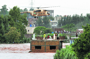 An army helicopter hovers to rescue trapped people from a flooded area on the outskirts of Islamabad on Friday.