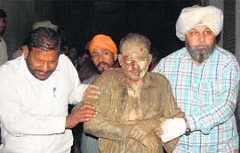 An injured person being taken to hospital by fire brigade officials. He was trapped after a residential building collapsed in Mahindra Colony in Amritsar on Friday.