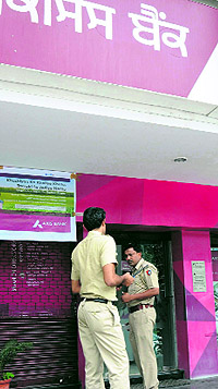 Police officials inspect an ATM in the Sector 9 market. An attempt was made to break the ATM of AXIS Bank in Chandigarh on Saturday