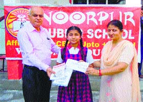 Divayanshi, a Class VI student, receives a prize for winning an essay writing competition organised by the Union HRD Ministry in Nurpur on Saturday