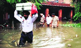 A policeman moves official records from a flooded police station in Gidderbaha on Saturday.