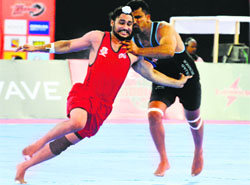 A Punjab Thunder player (in black) trying to stop a Khalsa Warriors raider from scoring a point during their match in Ludhiana on Saturday.