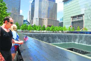 Emotional visitors scan names of 9/11 victims, inscribed on the memorials sunken pools parapets
