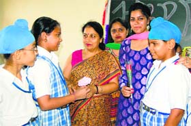 Students present flowers to their teachers at Ashmah International School