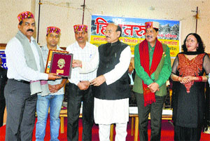 Health and Revenue Minister Kaul Singh Thakur (c) presents an award to District Health Officer Sushil Chander (extreme left) during a function in Kullu on Saturday.