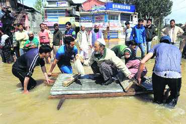 People being rescued on a make-shift raft in Srinagar on Sunday. PTI