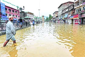 A man wades through a waterlogged street in Srinagar. PTI