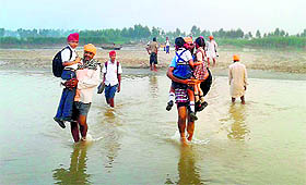parents carry their wards to a school at Baopur village near Sultanpur Lodhi in Kapurthala; 