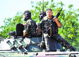 Ukrainian soldiers patrol after an overnight bombing attack on the outskirts of the key port city of Mariupol, on Sunday.