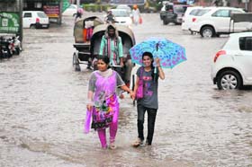 RAIN WALK: Girls walk through a waterlogged street in Bathinda on Monday