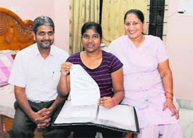 Priya Garg, along with her parents, shows the letter of scholarship in Bathinda on Monday