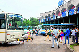 Commuters at a bus stand in Panchkula on Monday.
