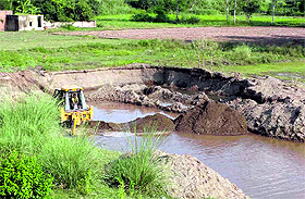 An earthmover excavates sand in Sanauli village near Zirakpur.