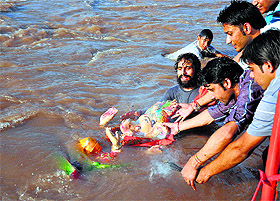 Devotees immerse an idol of Lord Ganesha in the Tawi in Jammu on Monday. 