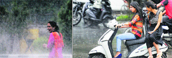 Showery surprise: A girl enjoys rain in Ludhiana on Monday; and (right) commuters brave showers on a city road. The city received 2mm of rainfall on Monday. The maximum temperature recorded was 33 degree Celsius while the minimum was 27 degree Celsius.