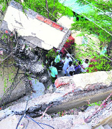 Residents look at the collapsed bathroom in the Maharaja Nagar area of Ludhiana on Monday.