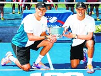 Mike Bryan and Bob Bryan pose with the trophy after their 100th career title win