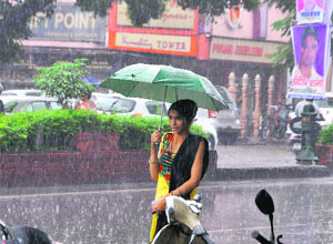 A girl walks through Rajpur Road on a rainy day in Dehradun on Monday.