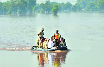 Pakistani soldiers use an inflatable boat to rescue flood-affected residents from a village at Jalalpur Bhattian in the Hafizabad district in Punjab province on Monday.