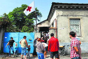 People wait for food outside a Red Cross building in the key southeastern port city of Mariupol, on Monday.