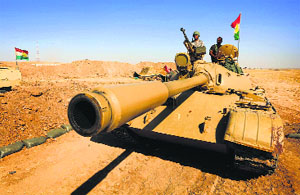 Iraqi Kurdish Peshmerga fighters stand on a tank as they hold a position on the front line in Khazer, Iraq, on Sunday.