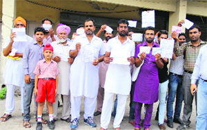 The residents, who were duped by the company owners, show the receipt of the money received by the company officials in Bathinda on Wednesday. 