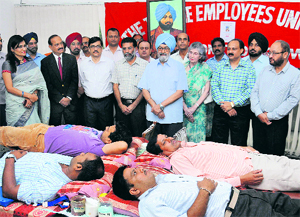 Tribune employees donate blood on the 116th death anniversary of The Tribune Trust founder, Sardar Dyal Singh Majithia, in Chandigarh on Tuesday. The Trust president, Justice SS Sodhi (retd) (centre), his wife Bonny Sodhi, and (from left) Principal of Tribune Model School Vandana Saxena, Editor-in-Chief Raj Chengappa, Punjabi Tribune Editor Varinder Walia, General Manager Vinay Verma and Tribune Employees Union president Anil Gupta (second from right) were present on the occasion. 