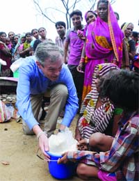 German Ambassador Michael Steiner donates a bucket of rice during the Rice Bucket Challenge at Vivekanand slums camp in Chanakyapuri, New Delhi on Tuesday.