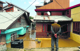A man looks at submerged houses in Srinagar